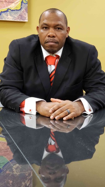 Chris Davios in a dark suit and red tie