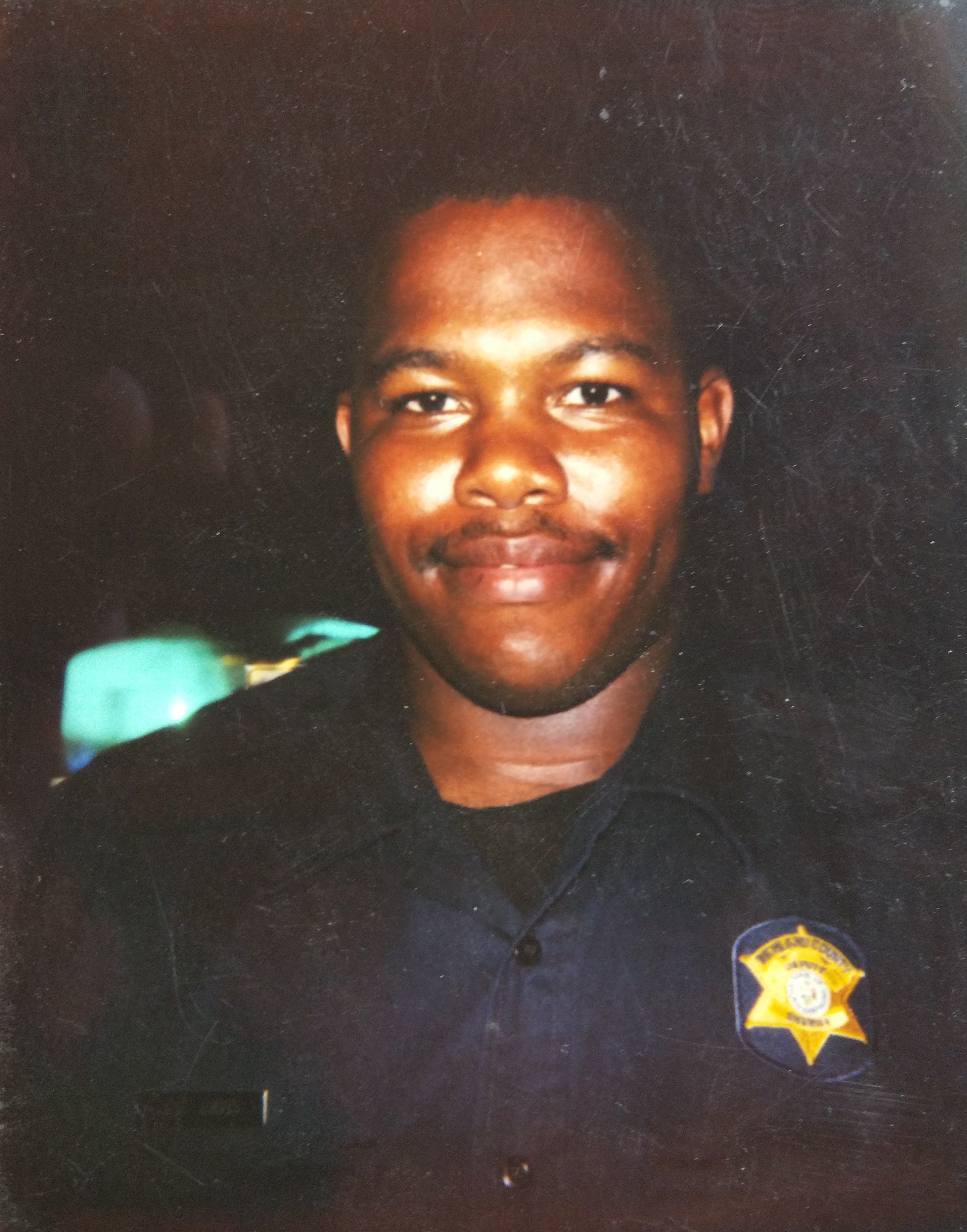 Chris Davios as a young law enforcement officer, wearing his sheriff's department uniform with badge